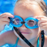 child with goggles swimming